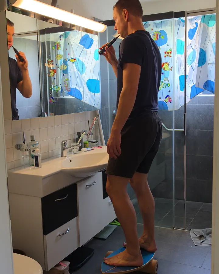 Mann rasiert sich auf dem Balance Board
